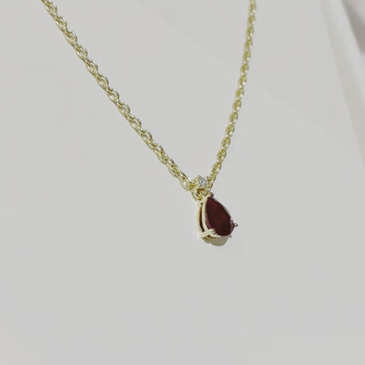 Video review of A model is wearing pear drop Ori necklace and hexagon Melba earrings set with lab grown ruby and diamond gem stones. She is also wearing trinagle Diana ring and princess Forma bracelet.